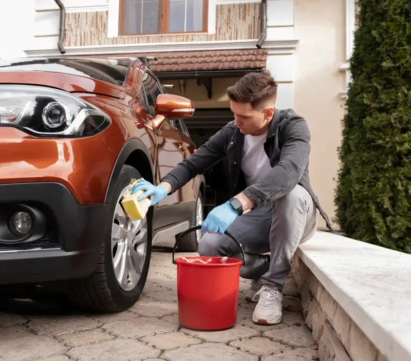 Lavage auto à domicile Fesmy-le-Sart : professionnel intervenant sur un véhicule
